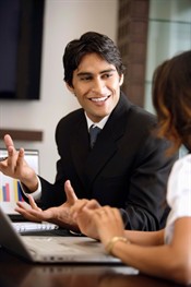 Photo of a young man presenting in front of his laptop