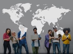 Diverse group of people standing below a world map.