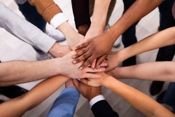 Diverse group of people stacking hands together.